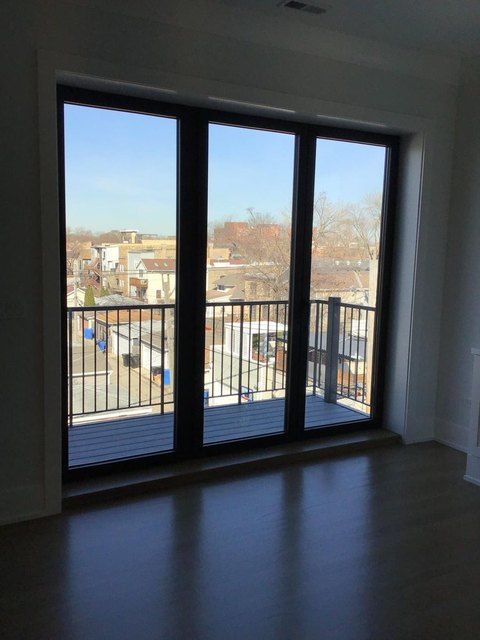 Bright unit with clean floor-to-ceiling windows and wood floors