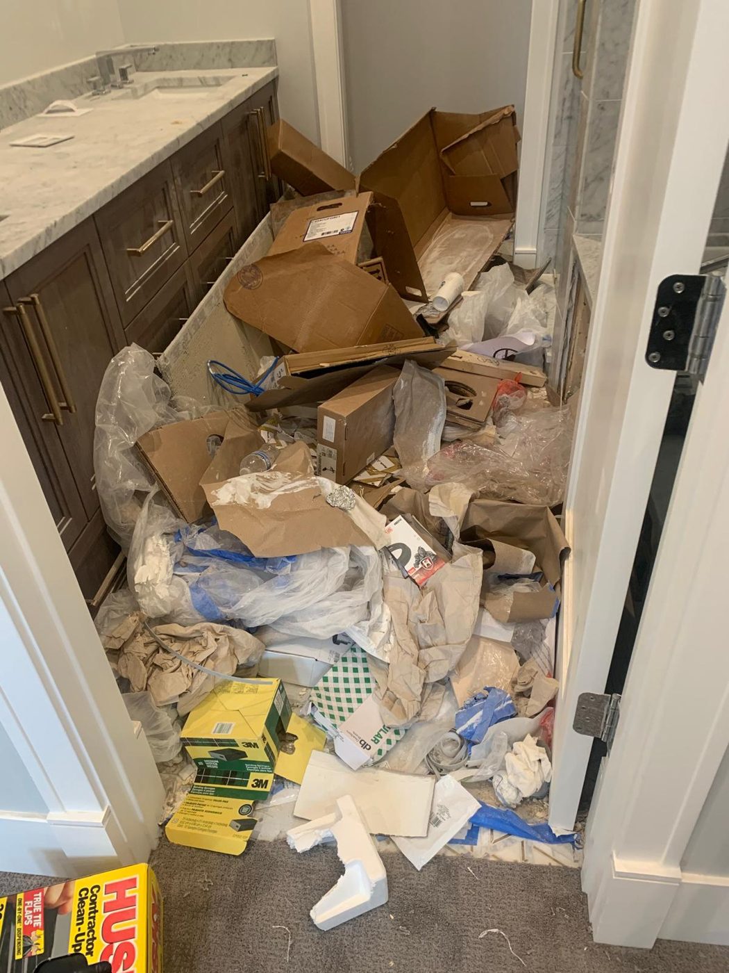 Bathroom filled with debris and boxes before cleanout