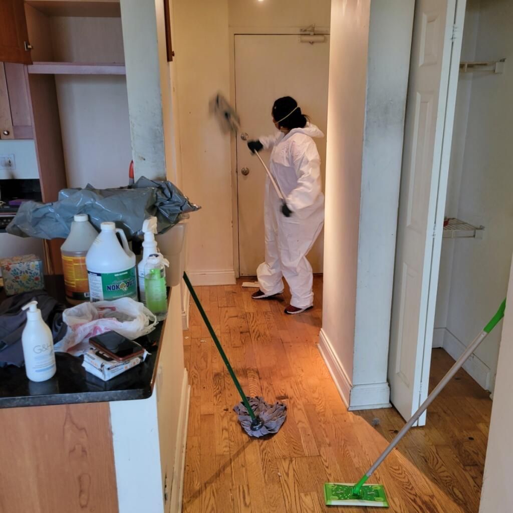 Ale Cleaning team member in protective gear mopping hardwood floors