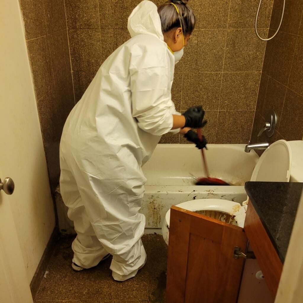 Team member scrubbing and restoring a bathtub